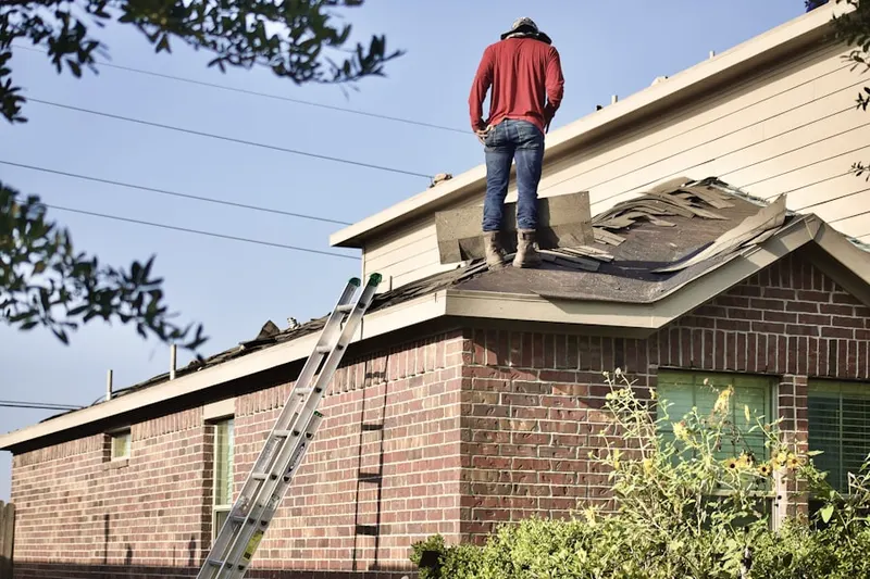 Professional roofer working on a residential roof in East Side
